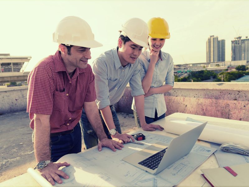 Multi-ethnic group of engineers meeting at construction site in eveing time