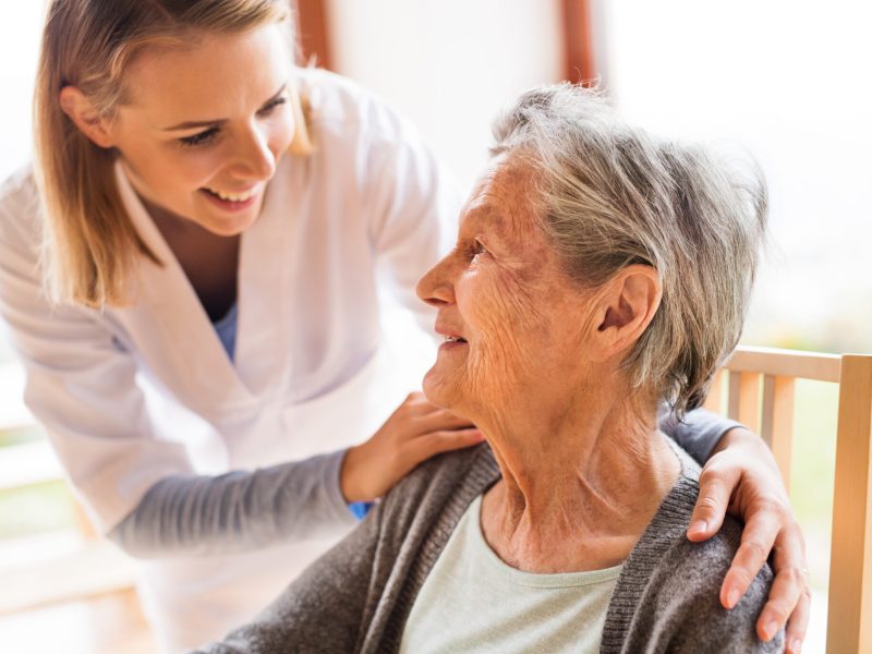 Health visitor and a senior woman during home visit.