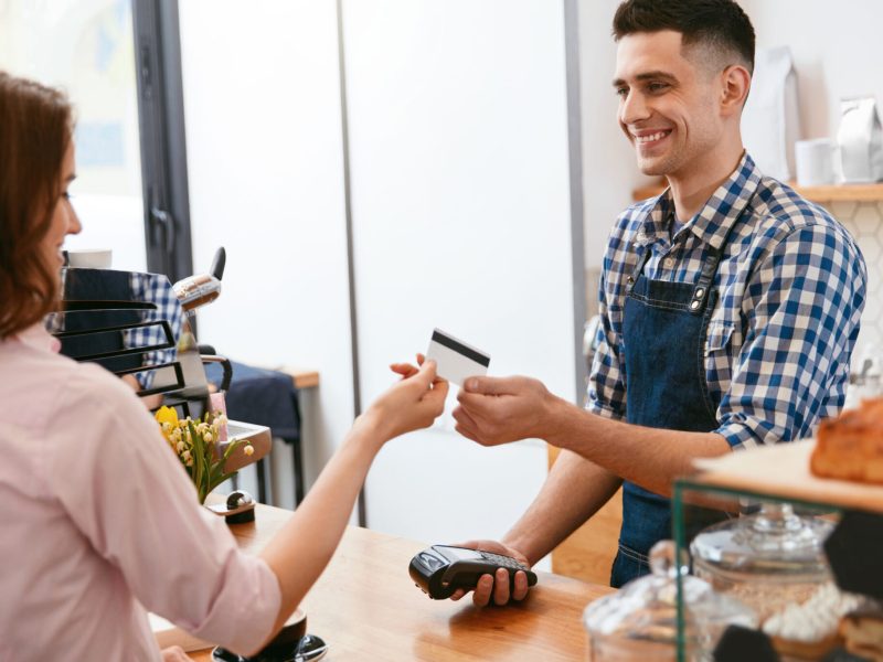 Buy Coffee. Woman Paying With Credit Card In Cafe