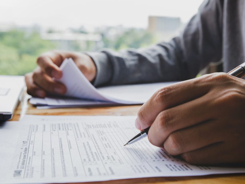 Closeup of man hand filling income tax forms