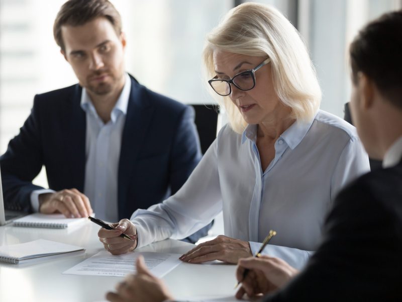 Concentrated aged businesswoman checking agreement before signin