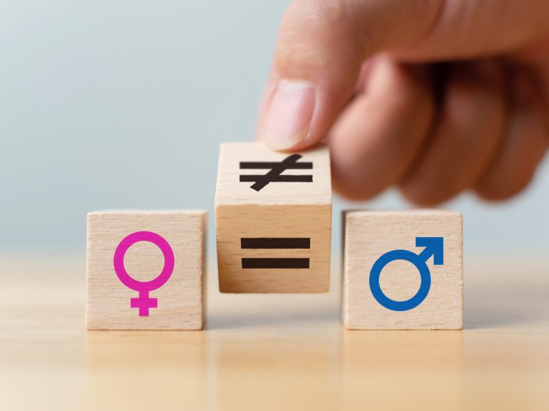 Concepts of gender equality. Hand flip wooden cube with symbol unequal change to equal sign