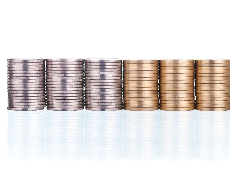 Silver and golden coins stacks on white