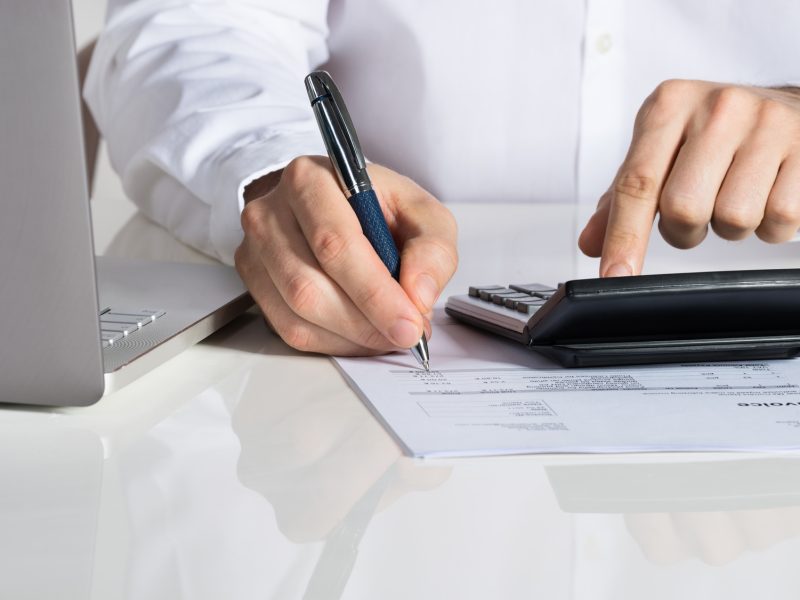 Businessman Calculating Invoice By Laptop