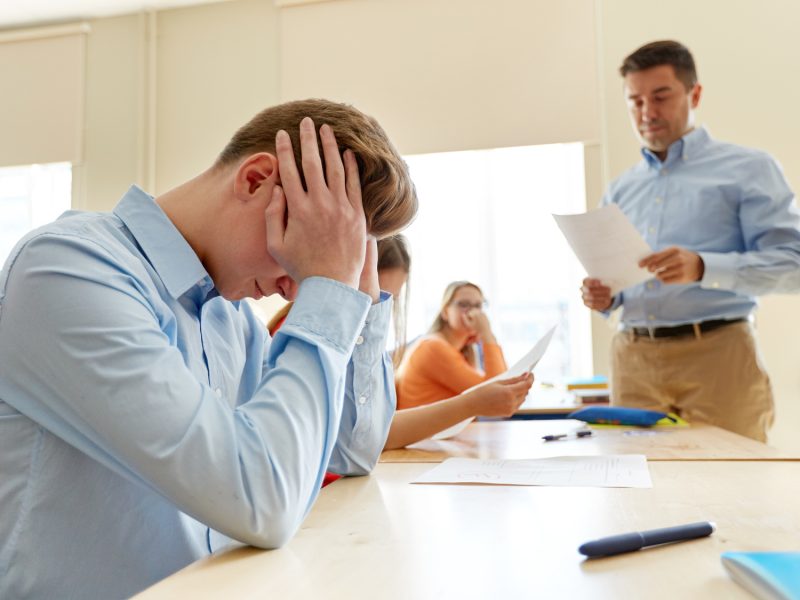 teacher giving test results to group of students