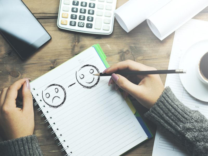 woman wrting smileys on notebook