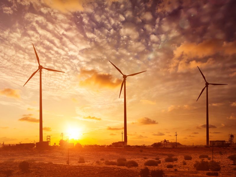 Wind generator turbines sihouettes on sunset