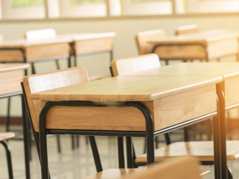 Empty School classroom with desks chair wood, and blackboard in high school thailand, vintage tone education concept