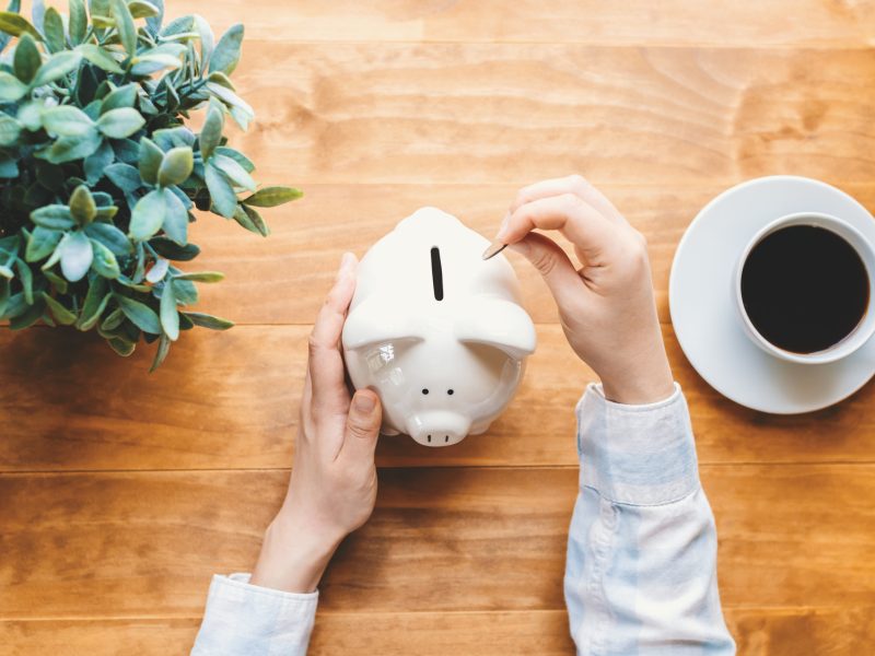 Woman holding a white piggy bank