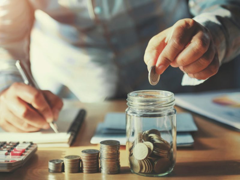 businessman saving money concept. hand holding coins putting in