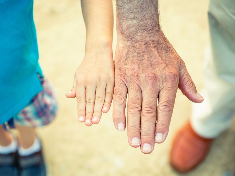 Child and senior man comparing his hands size