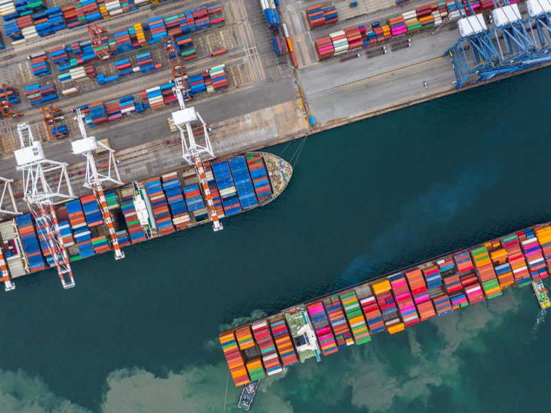 Aerial view cargo ship terminal, Unloading crane of cargo ship terminal, Aerial view industrial port with containers and container ship.