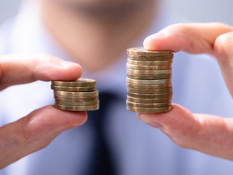 Man Comparing Two Coin Stacks