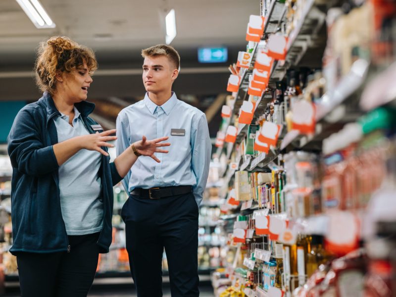 Supermarket manager giving training to a trainee