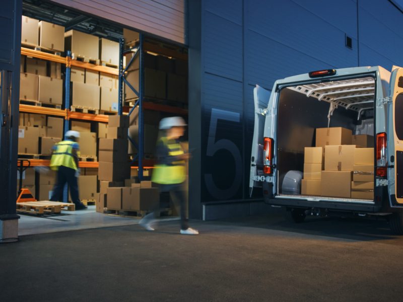 Outside of Logistics Distributions Warehouse Diverse Team of Workers Loading Delivery Truck with Cardboard Boxes. Online Orders, Purchases, E-Commerce Goods, Supply Chain. Blur Motion Shot.