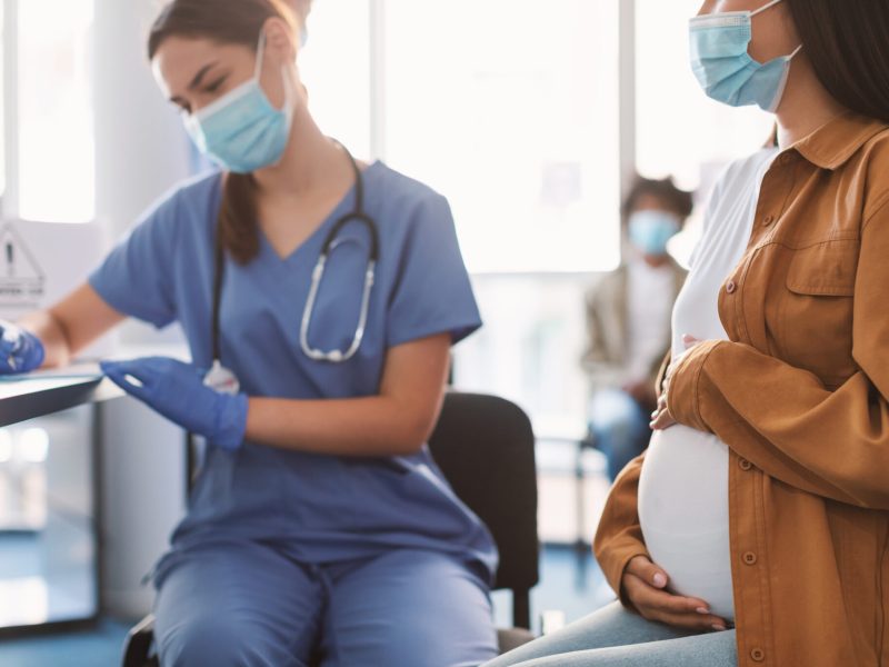 Pregnant Lady In Mask On Appointment At Doctor's Office