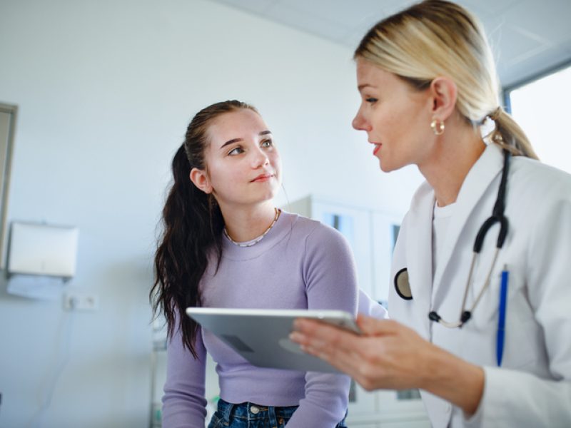 Young woman doctor explaining diagnosis to teenage girl in her ambulance.