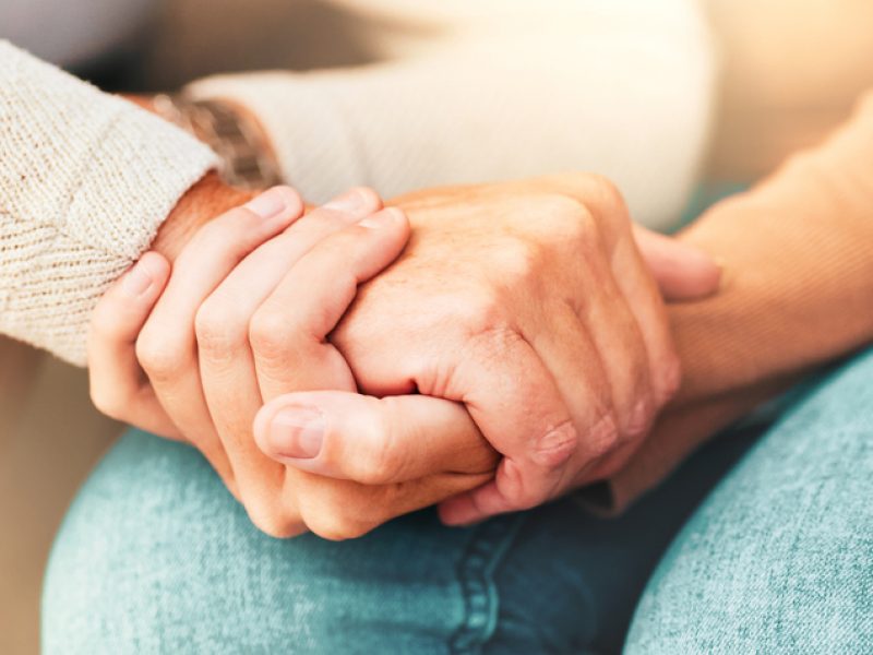 Support, trust and hands, senior care in therapy or grief counseling session. Love, care and understanding between elderly and and caregiver. Hope, empathy and help in time of need for mental health.