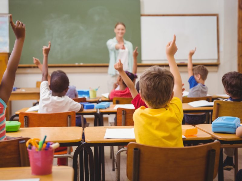 Students raising their hands during class