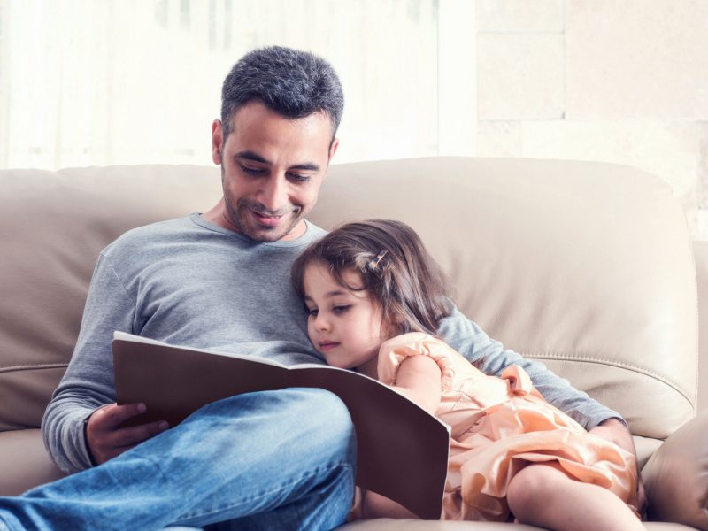 Little Girl And Father Reading Book Together