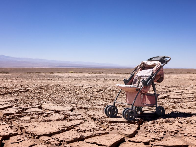 Desertification: symbolic image for climate change with old stroller and dry soil