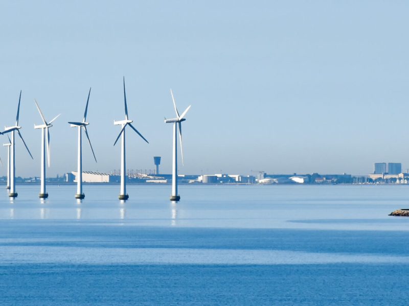 Offshore wind turbines on the coast of Copenhagen in Denmark with the airport in the background